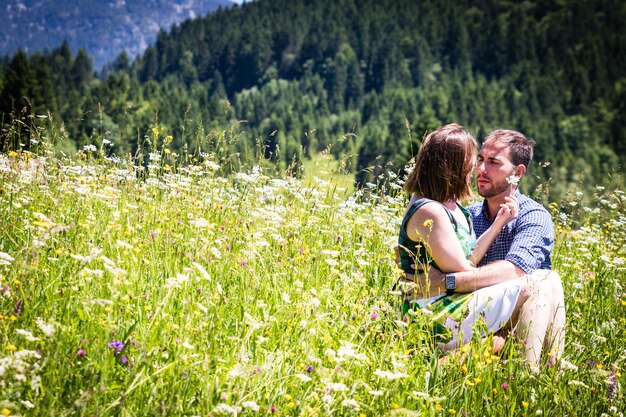 Foto la coppia seduta in mezzo alle piante in fiore