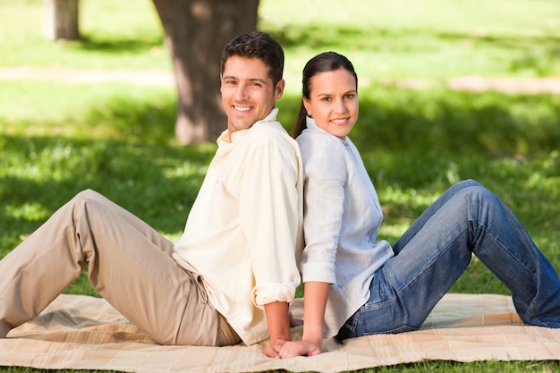 Couple sitting back to back in the park