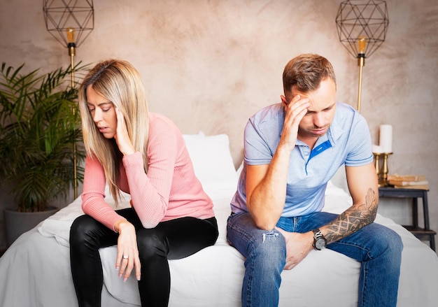 Couple sitting on bed and don't speak to each other