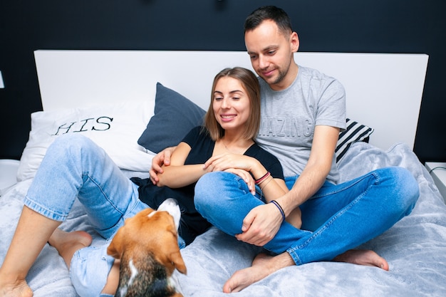 Couple sitting in bedroom with their dog