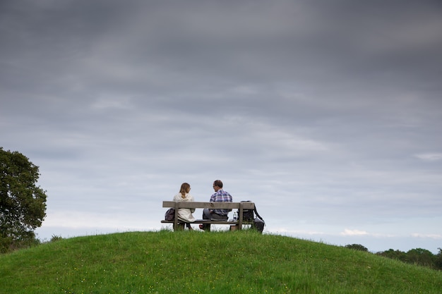 Couple sitting on bench in park. Lovers on the bench