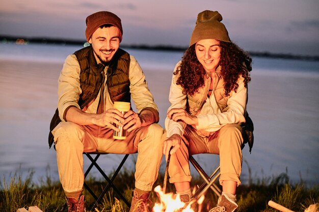 Couple sitting at bonfire