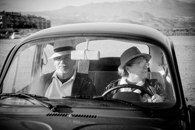 Couple sitting in car against mountains