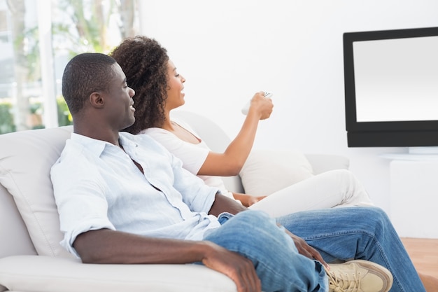 Couple sitting on couch together watching tv