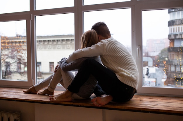 Couple sitting near window at home