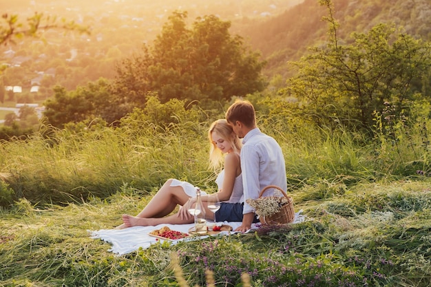 couple sitting on picnic while spending time together on the hill