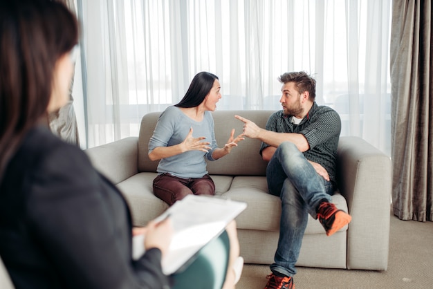 Couple sitting on sofa, psychologist reception