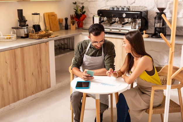 Couple sitting at the table and making plans about opening cafe