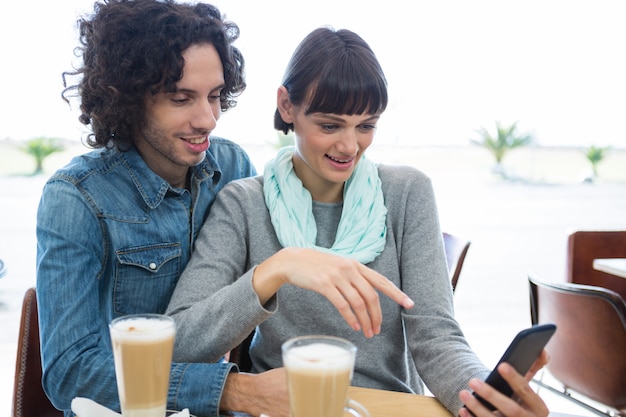 Couple sitting together and using mobile phone