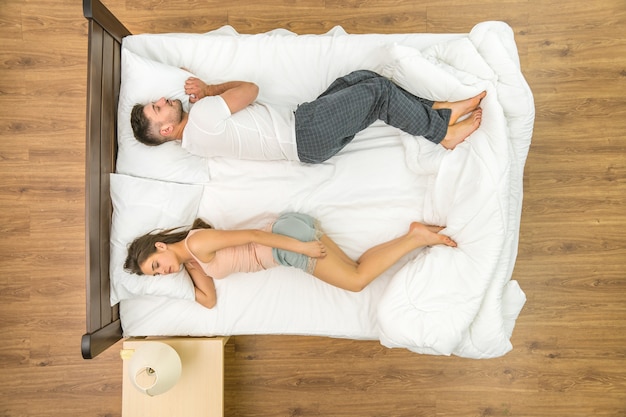 The couple sleeping on the bed. View from above