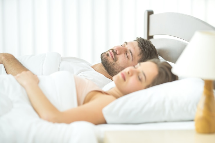 Photo the couple sleeping in the comfortable bed