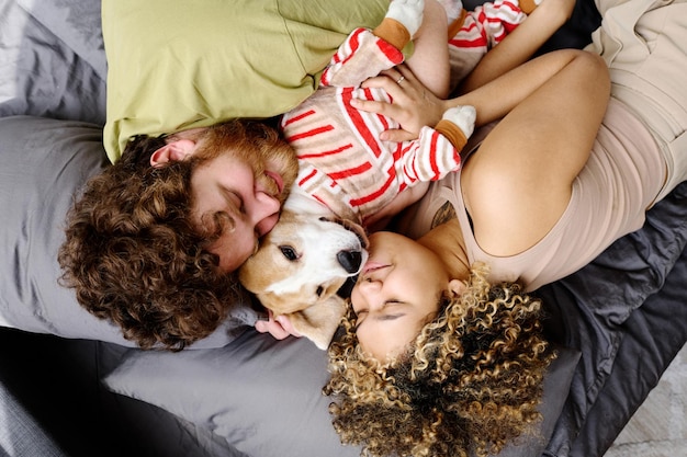 Couple sleeping in embrace with dog