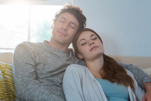 Couple sleeping together on sofa