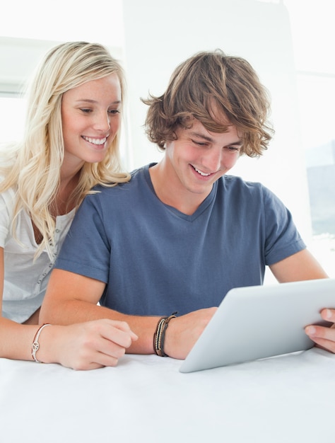 A couple smiling as they use a tablet