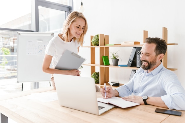 Coppia di colleghi sorridenti che parlano di lavoro