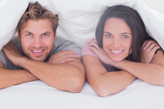 Couple smiling under the duvet