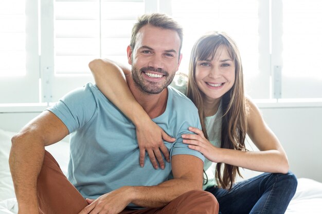 Couple smiling while relaxing on bed