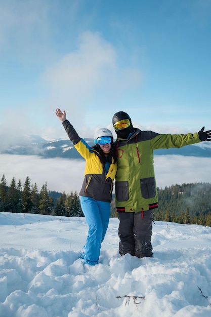 Пара сноубордист и лыжник портрет горы на заднем плане
