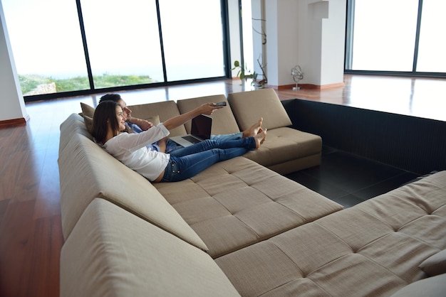 Couple on sofa with TV remote