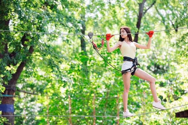 Couple spend their leisure time in a ropes course. man and\
woman engaged in rock-climbing,