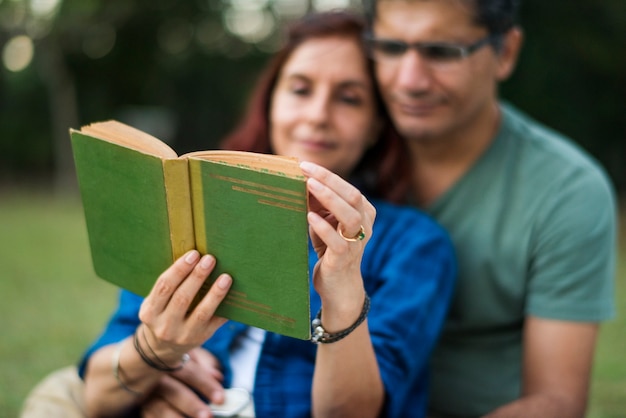 Couple spending time together reading a novel on a picnic in the jungle