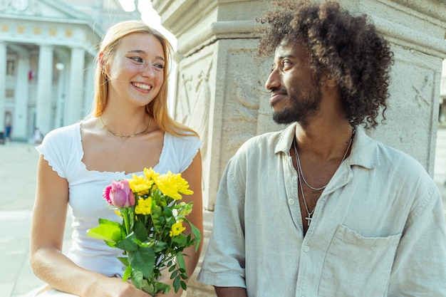 Foto una coppia trascorre un momento insieme a una donna con un bouquet di fiori ricevuto dal suo partner