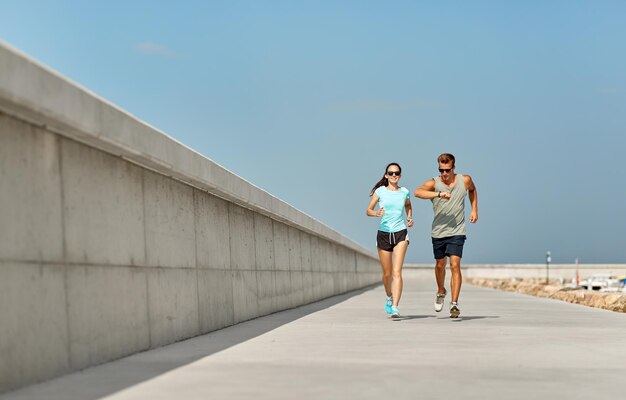 Photo couple in sports clothes running outdoors