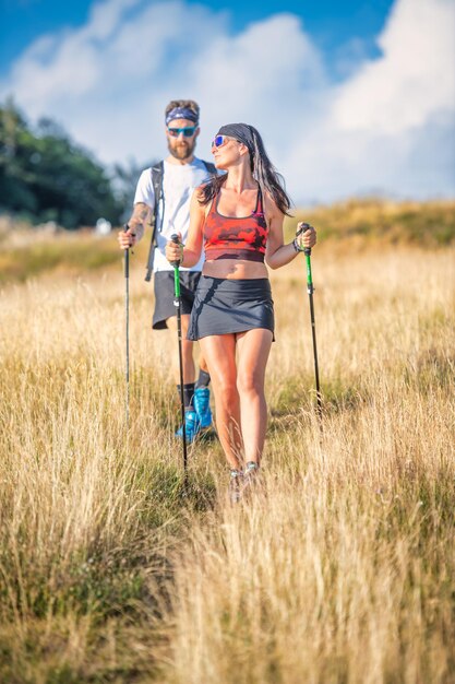 Couple of sportsmen during nordic walking exercise