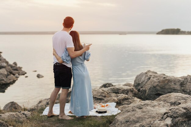 물을 바라보는 해변에 서 있는 커플