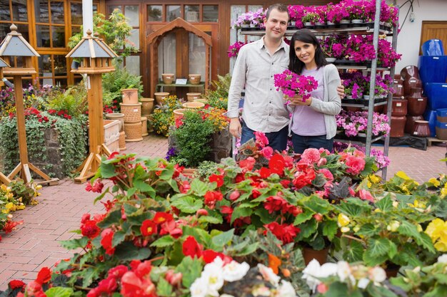 Couple standing holding bunch of purple flowers