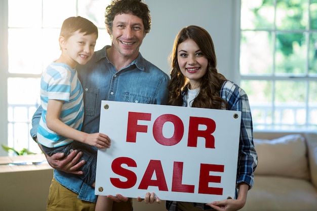 Couple standing and holding sold sign