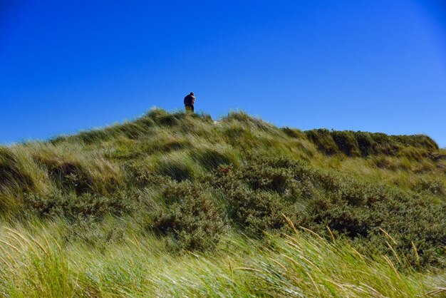 Couple standing on mountain against sky