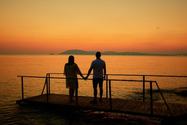 Couple standing on the sunset on the beach