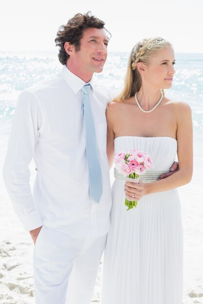 Couple standing together on their wedding day looking away