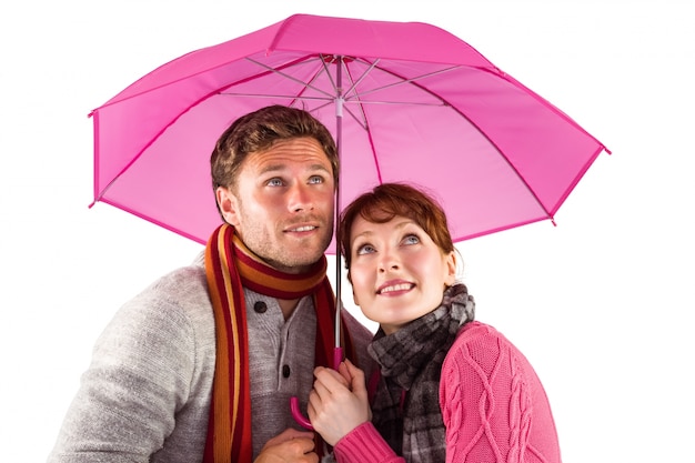 Couple standing underneath an umbrella