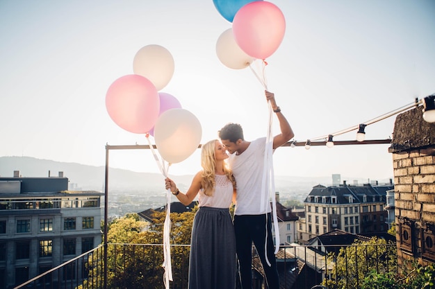 Foto coppia in piedi con i palloncini contro il cielo