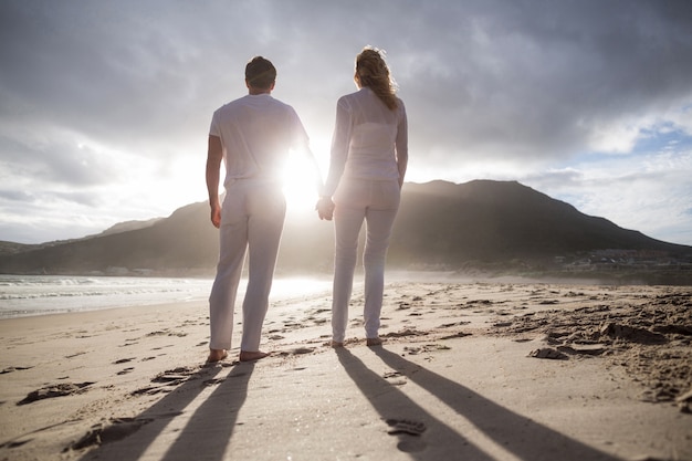 Couple standing with holding hands on the beach