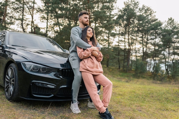 Couple stands near car