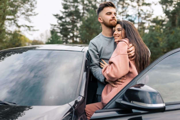 Couple stands near car