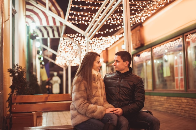 Photo couple at the street before christmas time. bokeh lights decorations backdrop