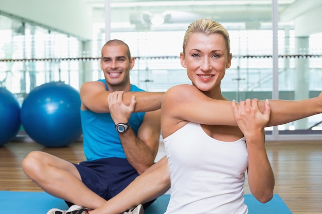 Couple stretching hands in yoga class