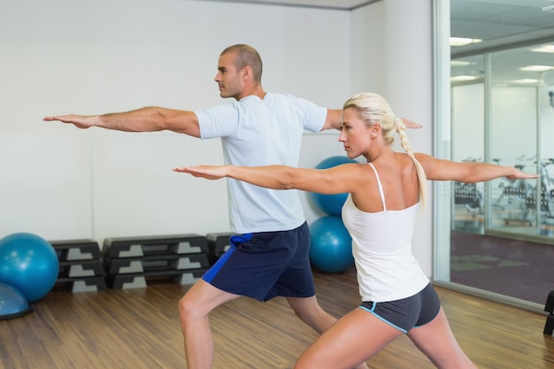 Couple stretching hands in yoga class