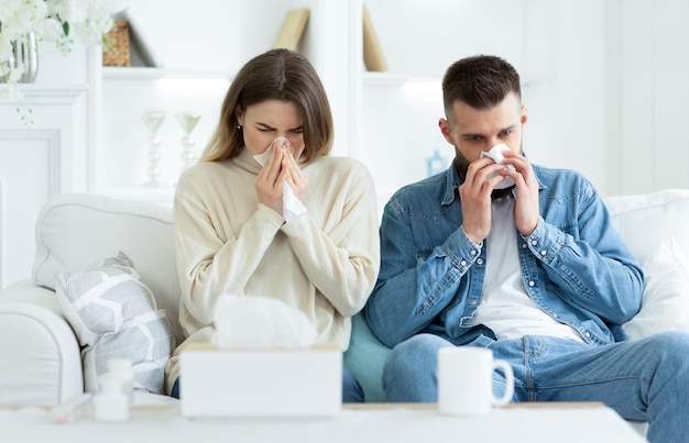 Coppia che soffre di naso che soffia freddo e starnuti