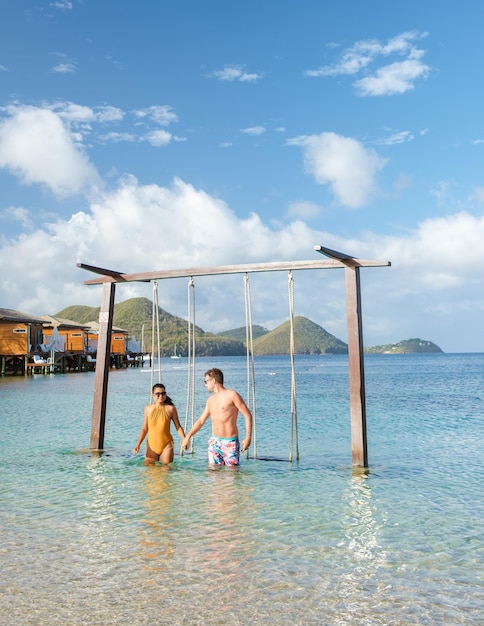 Couple in a swing on the beach of the tropical island saint\
lucia or st lucia caribbean