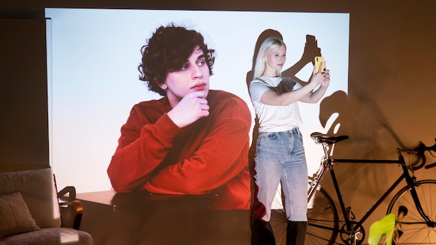 Couple taking photos in the light of movie projector