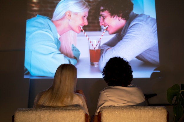 couple taking photos in the light of movie projector