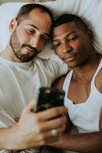 Photo couple taking a selfie in bed