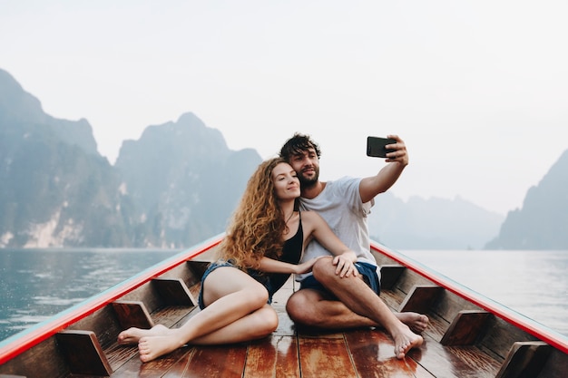 Coppia prendendo selfie su una barca longtail