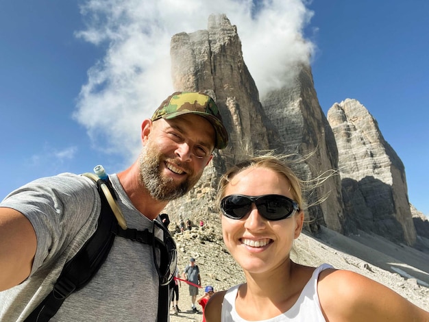 Photo couple taking a selfie in the tre cime hike in dolomites
