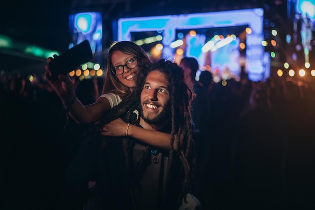 Фото Пара делает селфи со смартфоном на музыкальном фестивале
